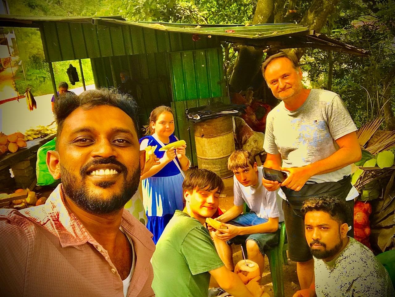 Family with children enjoying local food stop on tuk tuk tour in Sri Lanka countryside