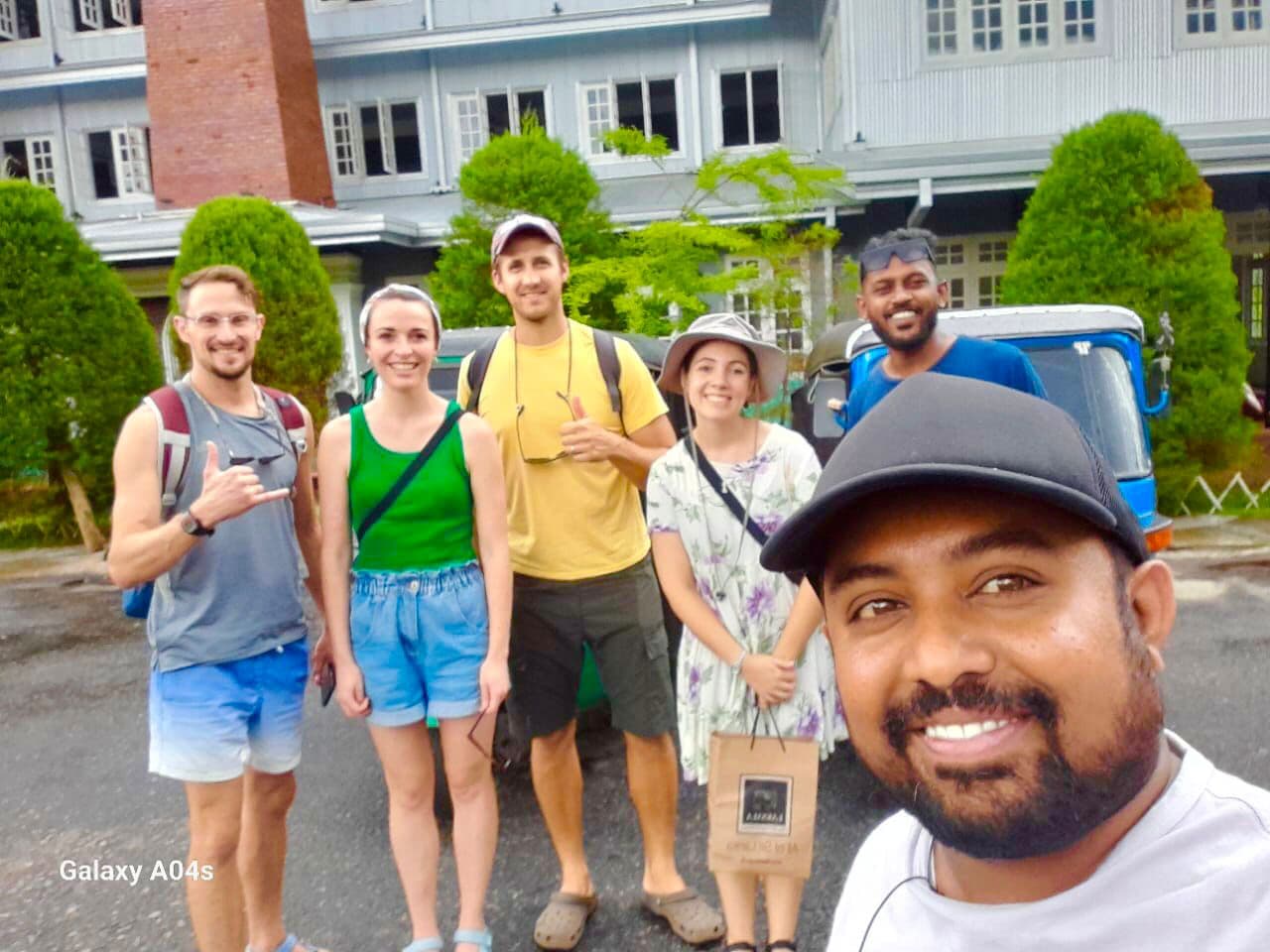 Tourist group with tuk tuk at colonial building in Nuwara Eliya Little England